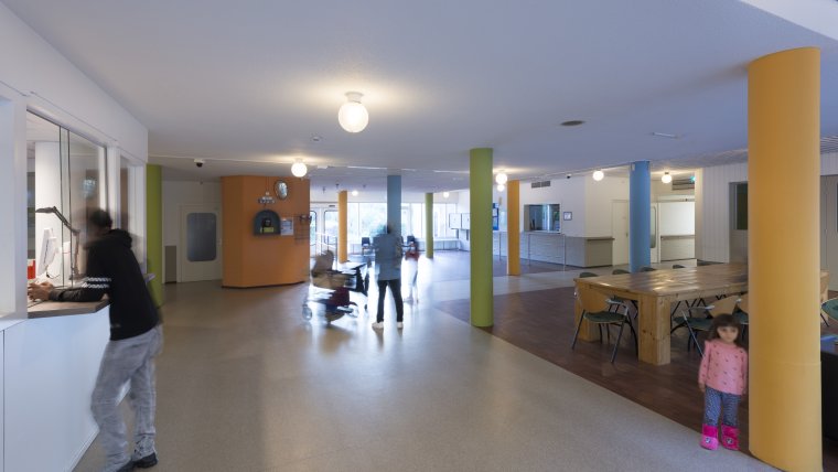informatiebalie en wachtruimte met gekleurde pilaren en bewoners