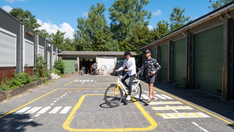 Twee bewoners oefenen buiten met fietsen
