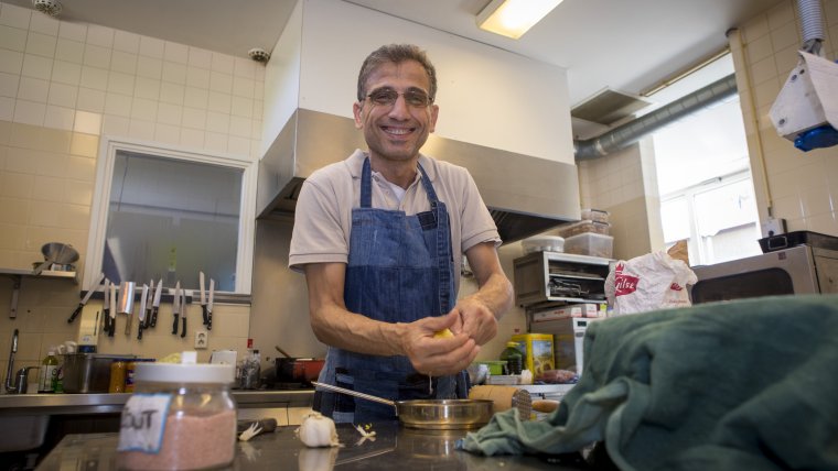 Eiad aan het werk in de keuken van eetcafé Athos EET