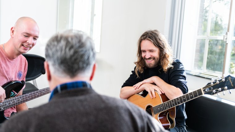 drie mannen spelen muziek in azc
