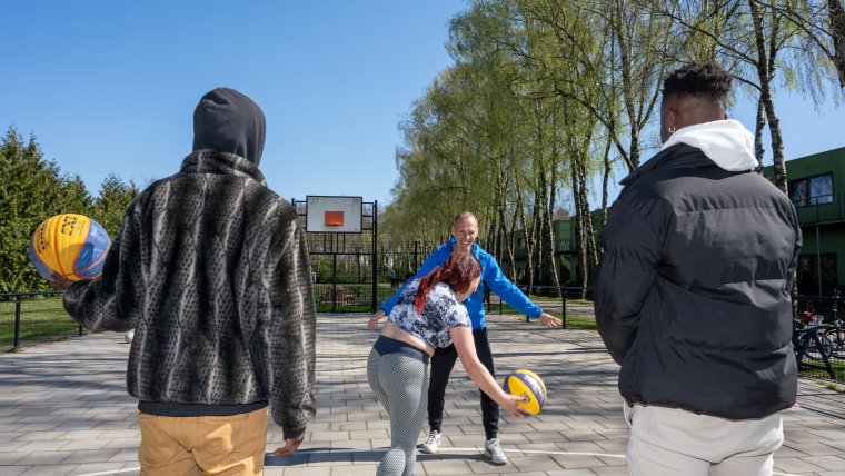 bewoners aan het basketballen met een sportcoach