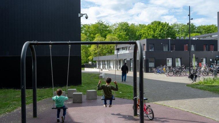 2 kinderen op de schommel voor het gebouw van coa locatie Zutphen
