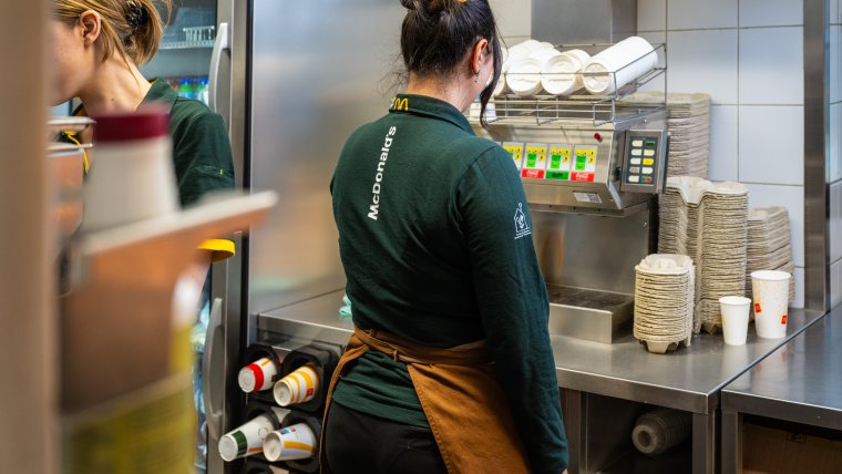 Vrouw staat in keuken fastfoodketen