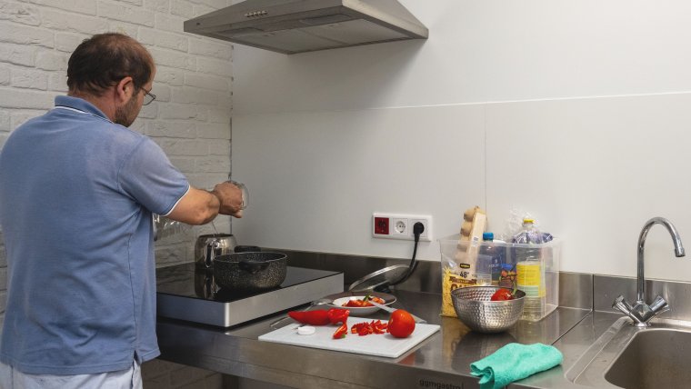 Mannelijke bewoner staat te koken in de keuken