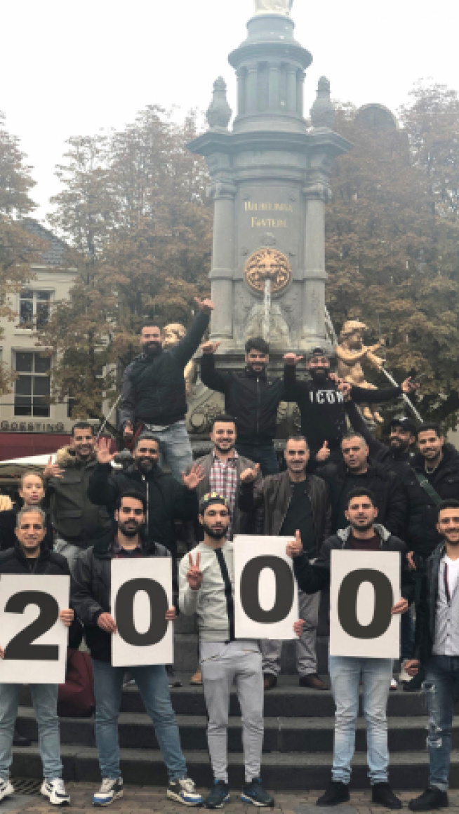 groep poseert met 2000 op borden