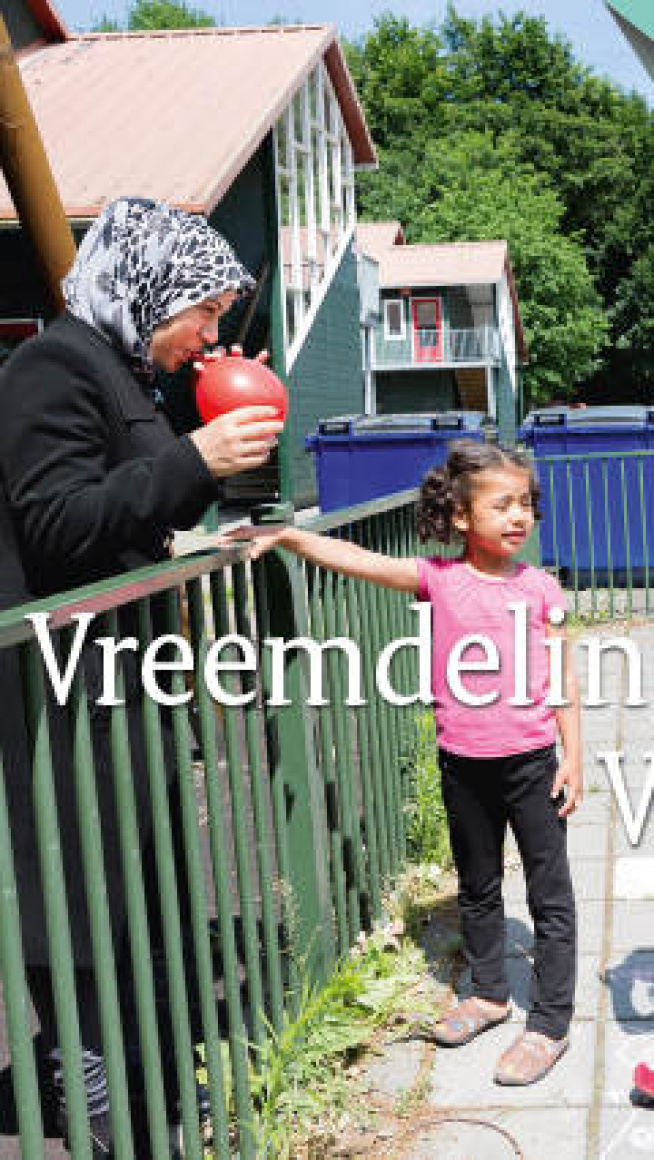twee meisjes staan bij een vrouw die een ballon opblaast