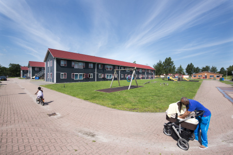 Man met kinderwagen en fietsend meisje bij gezinslocatie Burgum