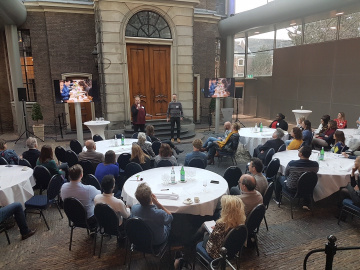 Mensen zitten aan een tafel in een zaal