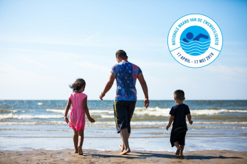 man loopt met kinderen op het strand