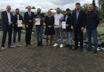 gerard bakker poseert met bewoners die diploma gehaald hebben