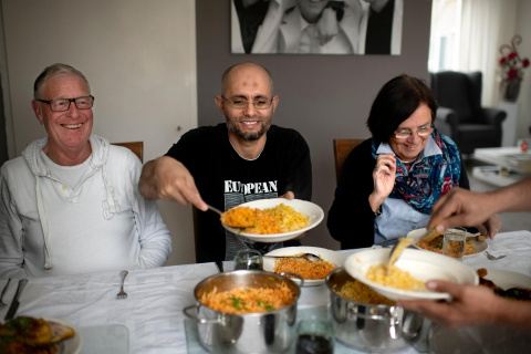 Asielzoeker eet een maaltijd met zijn buddy's