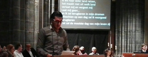 man leest tekst voor op podium