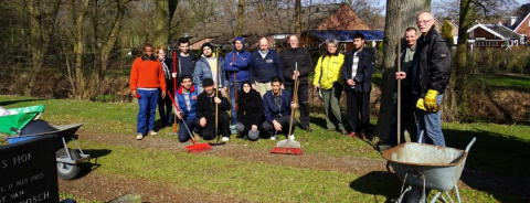 groep mensen poseer buiten met harken