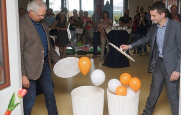 twee mannen openen een mand waaruit ballonnen opstijgen