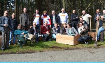 groep mensen poseert met schoffels en sommige zitten in een kar of bak