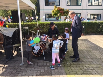 mensen staan om een muzikant heen met drumstel