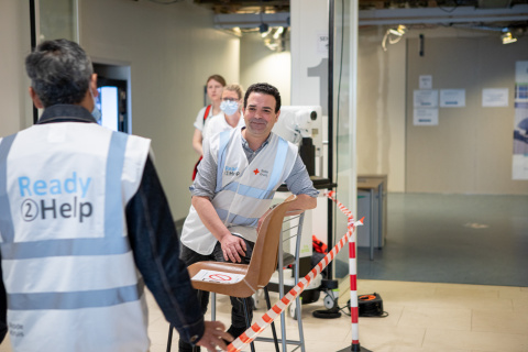 Twee bewoners van het COA staan op de gang met op de achtergrond twee verpleegkundigen. De bewoners assisteren in het Ikaziaziekenhuis