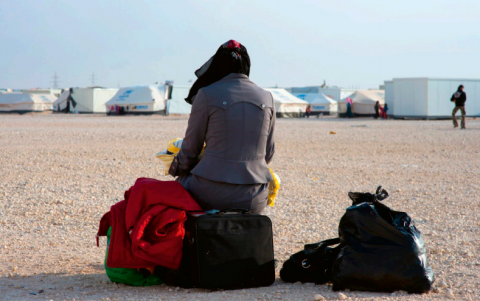 Vrouw met haar bagage in vluchtelingenkamp