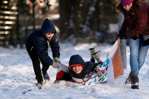 Asielzoekersinderen spelen buiten in de sneeuw 