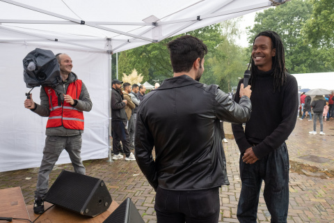 Bewoner interviewt Jeangu Macrooy rijdens Oen  dag in azc Gilze