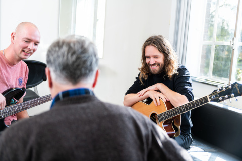 drie mannen spelen muziek in azc