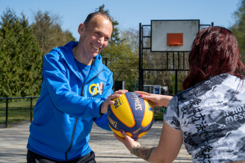 trainer geeft bal aan bewoner