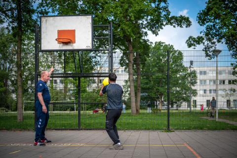 coach en bewoner basketballen voor het azc
