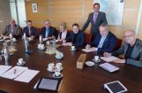 groep mensen poseert aan een vergadertafel