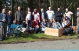 groep mensen poseert met schoffels en sommige zitten in een kar of bak