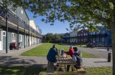 3 bewoners aan een picknicktafel op binnenplaats van opvanglocatie