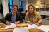 man en vrouw tekenen overeenkomst in kantoor