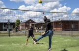sporters buiten in actie bij volleybal net