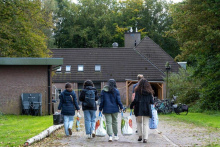 Jongeren die lopen op azc-locatie met boodschappentassen