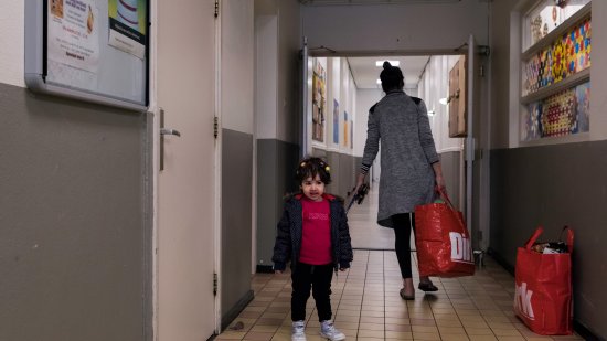 Moeder en kind met boodschappen in het azc 