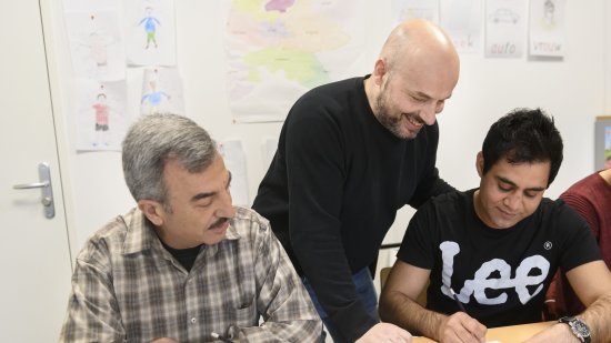 Programmabegeleider COA helpt statushouders tijdens les Kennis van de Nederlandse Maatschappij