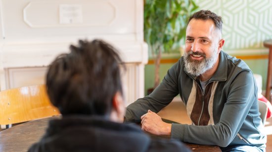Locatiemanager Menno Schot in gesprek met bewoner azc