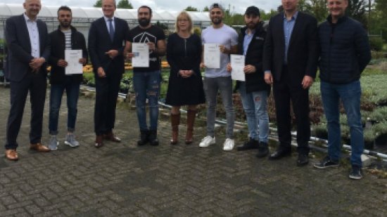 gerard bakker poseert met bewoners die diploma gehaald hebben