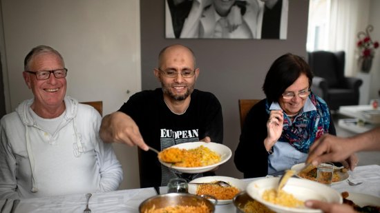 Asielzoeker eet een maaltijd met zijn buddy's