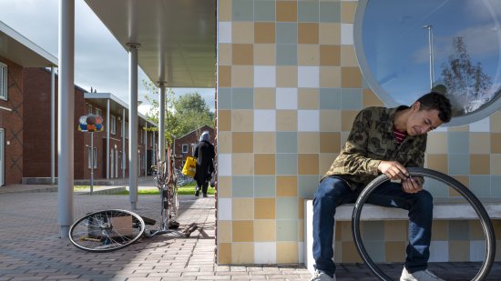 Asielzoeker plakt zijn band in de opvanglocatie Ter Apel