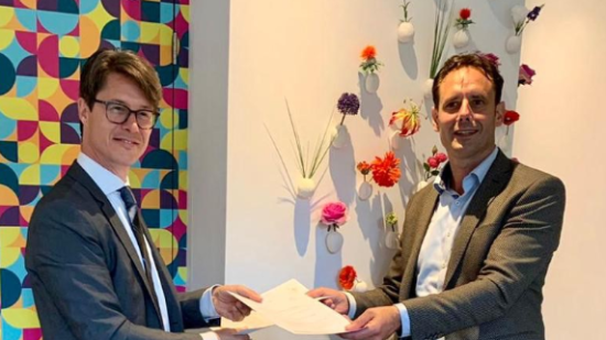 Joeri Kapteijns en burgemeester Harm Jan van Schaik van Harderwijk houden de net getekende bestuursovereenkomst vast.
