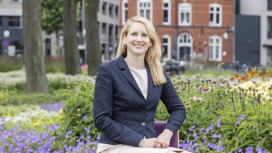 vrouw zit op bankje in park, paarse bloemen om haar heen