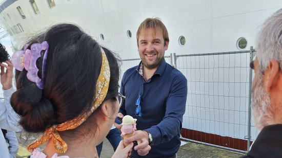 man deelt ijs uit aan azc-bewoners