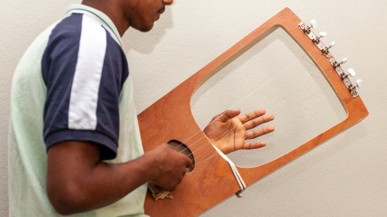 jongen speelt soort van harp