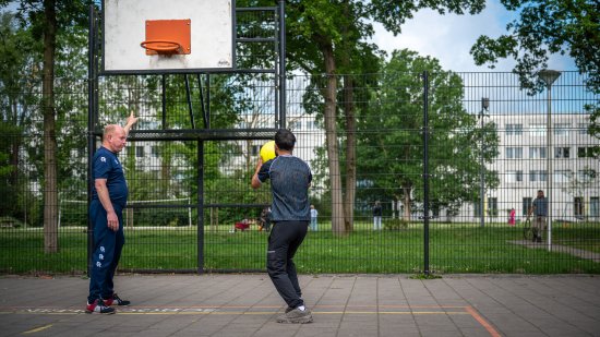 coach en bewoner basketballen voor het azc